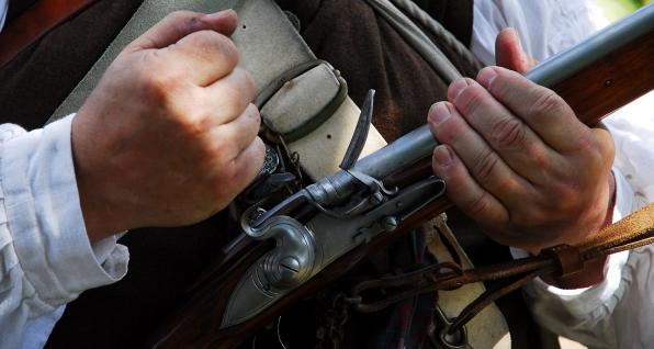 Revolutionary War re-enactor holds long gun