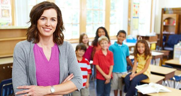 Teacher standing in front of young students in a classroom